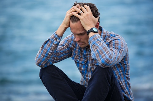 This sad man might benefit from CBT - a man struggling nearby a pier wearing blue plaid shirt