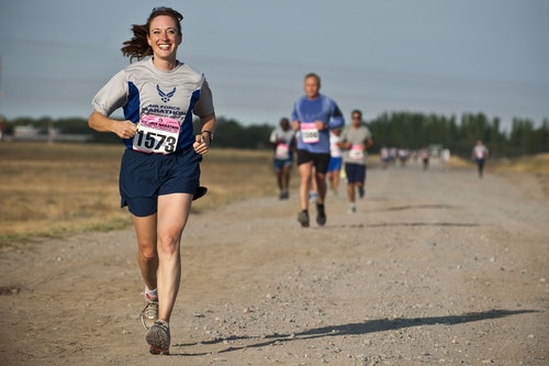 a woman looking very happy while running on a marathon